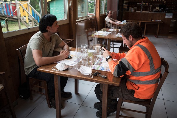 Two customers of the restaurant attached to the pool sit at the table, separated by plexiglass made mandatory by the new regulations against coronavirus. Lugo, Italy, 20 May 2020. (Photo by Andrea Savorani Neri/NurPhoto via Getty Images) (Foto: NurPhoto via Getty Images)