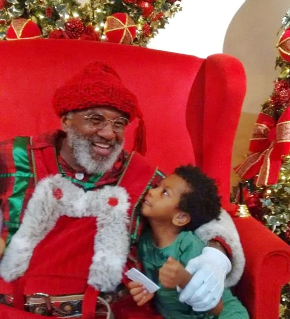 Rubens ao lado do garoto Diego, que ficou eufórico ao encontrar o Papai Noel negro — Foto: Arquivo pessoal/ Adriana Simões