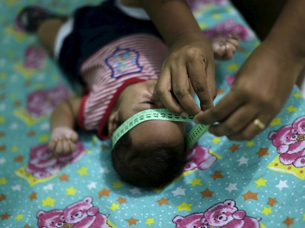   Diagnosticado com microcefalia, bebê Guilherme Soares Amorim, de 2 meses, tem a cabeça medida por sua mãe, Germana Soares, em sua casa em Ipojuca, em Pernambuco  (Foto: Reuters/Ueslei Marcelino)