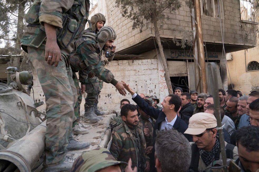 Presidente sírio, Bashar al-Assad, cumprimenta soldados em Guta Oriental, no domingo (18)  (Foto:  Sana/Reuters )