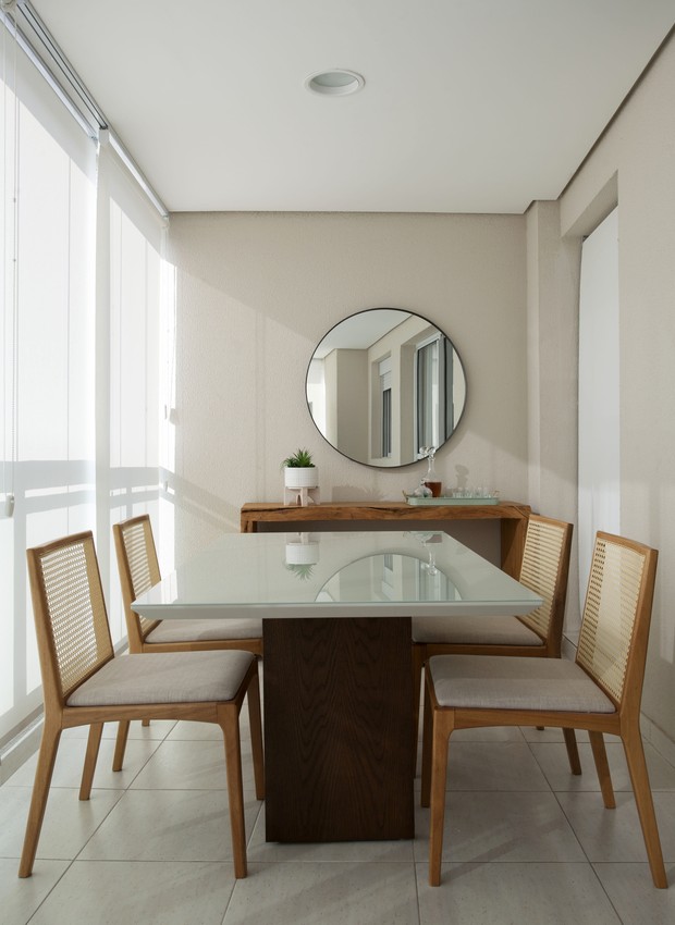 VARANDA | A sala de jantar foi instalada na varada e reaproveitou os móveis do acervo dos moradores. Espelho redondo da Líder Interiores (Foto: Marco Antonio/Divulgação)