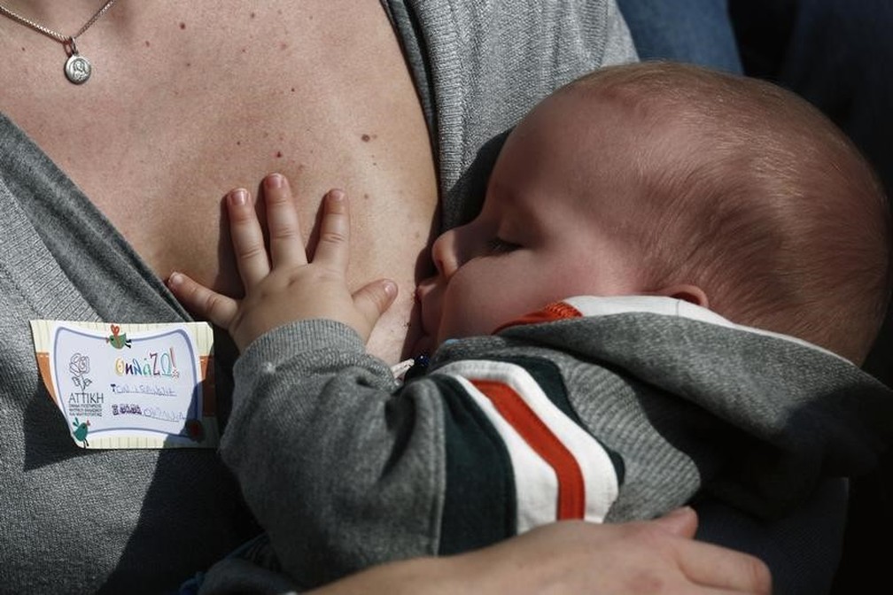 Mulher amamenta bebê durante evento em novembro de 2014 — Foto: Yorgos Karahalis/Reuters