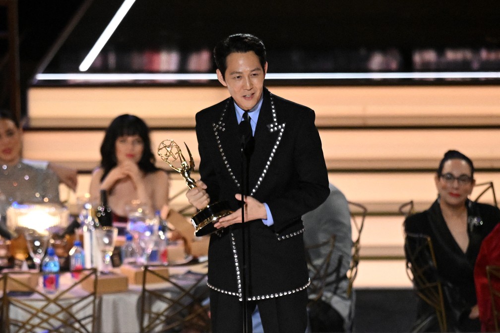 Lee Jung-jae agradece pelo prêmio de melhor ator em série de drama por 'Round 6' no Emmy 2022 — Foto: Patrick T. Fallon/AFP