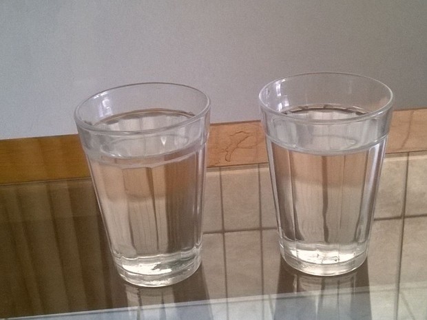 Moradora comparou água mineral (esquerda) e água que chega das torneiras (direita); as duas com a mesma coloração (Foto: Vania de Oliveira/ VC no ESTV)
