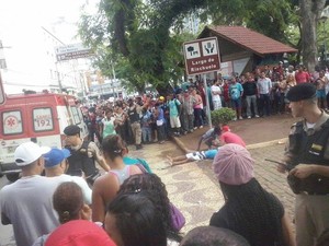 Vítima de tiro nesta sexta-feira (20) aguarda por socorro no Largo do Riachuelo (Foto: G1/G1)