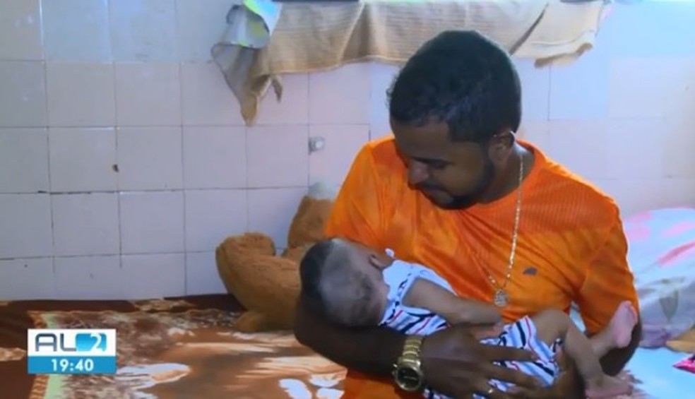 Bebê Davi, que foi abandonado  pela mãe em Maceió, AL, no colo do pai — Foto: Reprodução/TV Gazeta