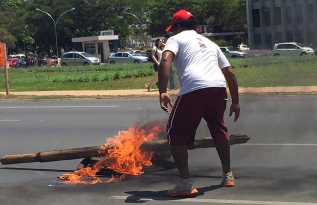 Manifestante ateia fogo em pedaço de madeira e em pneus no Eixo Monumental (Foto: Jéssica Nacimento/G1)