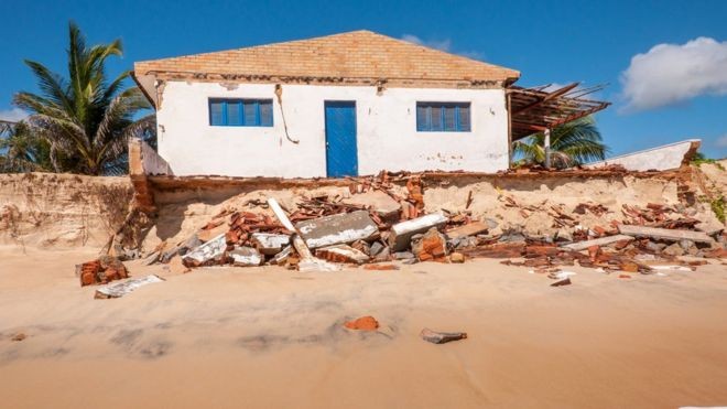 Na praia de Pititinga (foto), em Natal, o avanço do mar diminuiu a faixa de areia e engoliu construções (Foto: Getty Images via BBC)