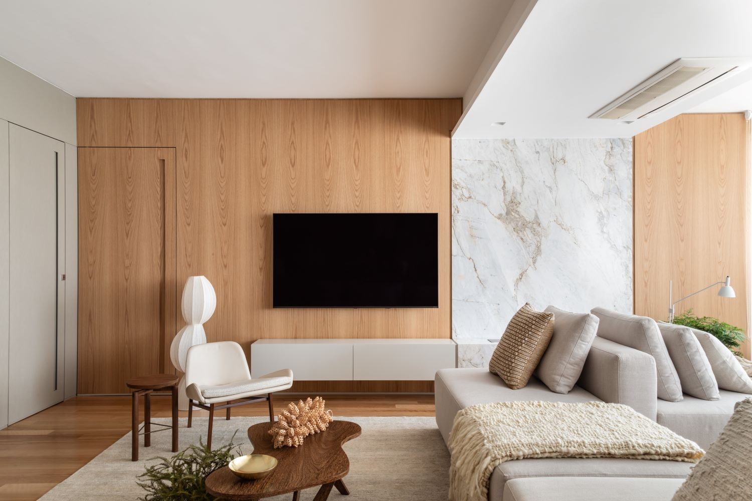 LIVING | O sofá, desenhado pelo escritório é um dos grandes destaques do projeto. A marcenaria fica por conta da Marcenaria Bossi e marmoraria da Pedras Morumbi (Foto: Divulgação / )