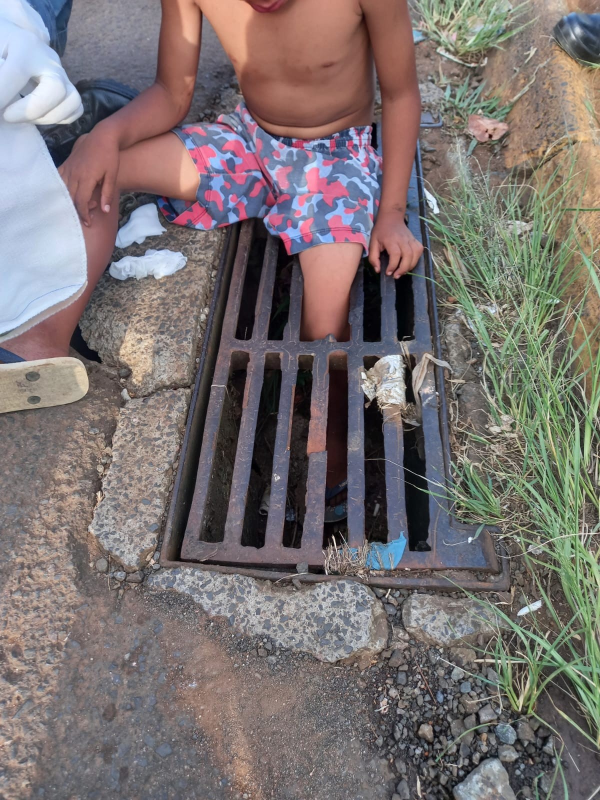 Criança pisa em vão de bueiro, cai e fica presa por uma das pernas em avenida de SC