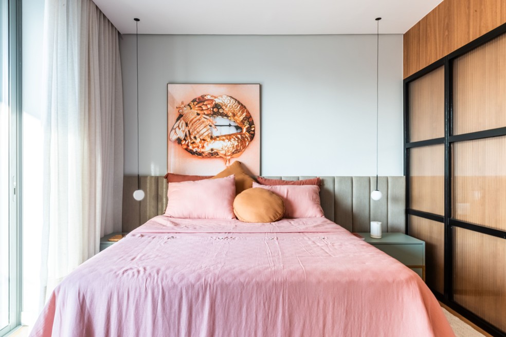 DÚPLEX DE RENATA: No quarto da irmã, a cabeceira estofada dá um tom mais clássico ao décor, que contrasta com a serralheira do closet, à dir. — Foto: Guilherme Pucci