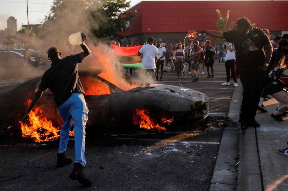 Grupo incendeia carro em Minneapolis, nos EUA, em protesto nesta quinta (28) contra morte de George Floyd — Foto: Carlos Barria/Reuters
