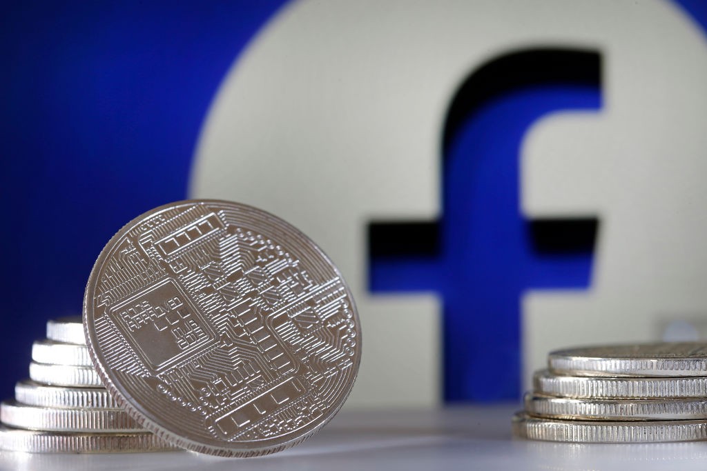 PARIS, FRANCE - JUNE 18: In this photo illustration, a visual representation of a digital cryptocurrency coin sits on display in front of a Facebook logo on June 17, 2019 in Paris, France. Facebook will announce Tuesday, June 18 the details of its cryptoc (Foto: Getty Images)
