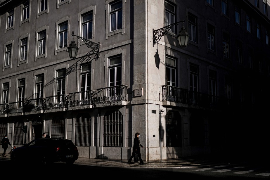 Mulher caminha próximo à sede do Banco de Portugal, no centro de Lisboa