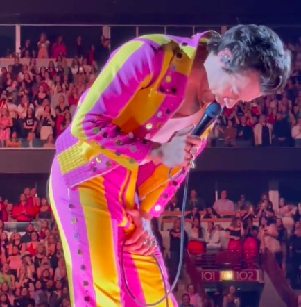 Musician Harry Styles bent over after being hit by a bottle at a concert in Chicago (Photo: Twitter)