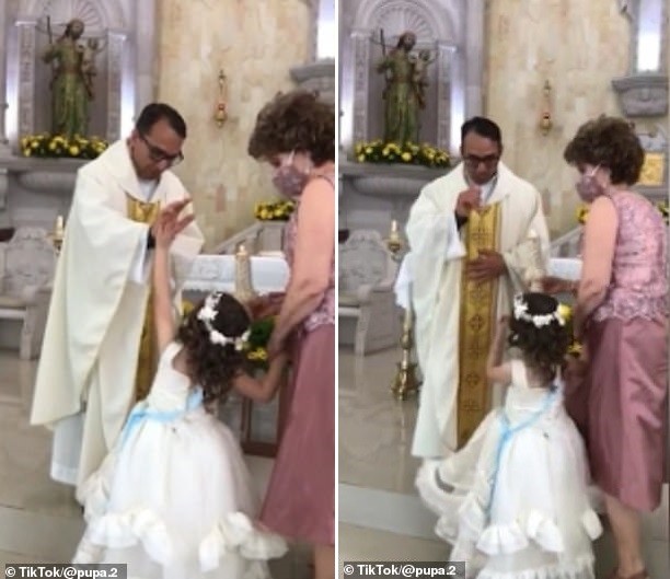 Menina diverte ao tocar na mão do padre durante bênção (Foto: Reprodução/Tik Tok)