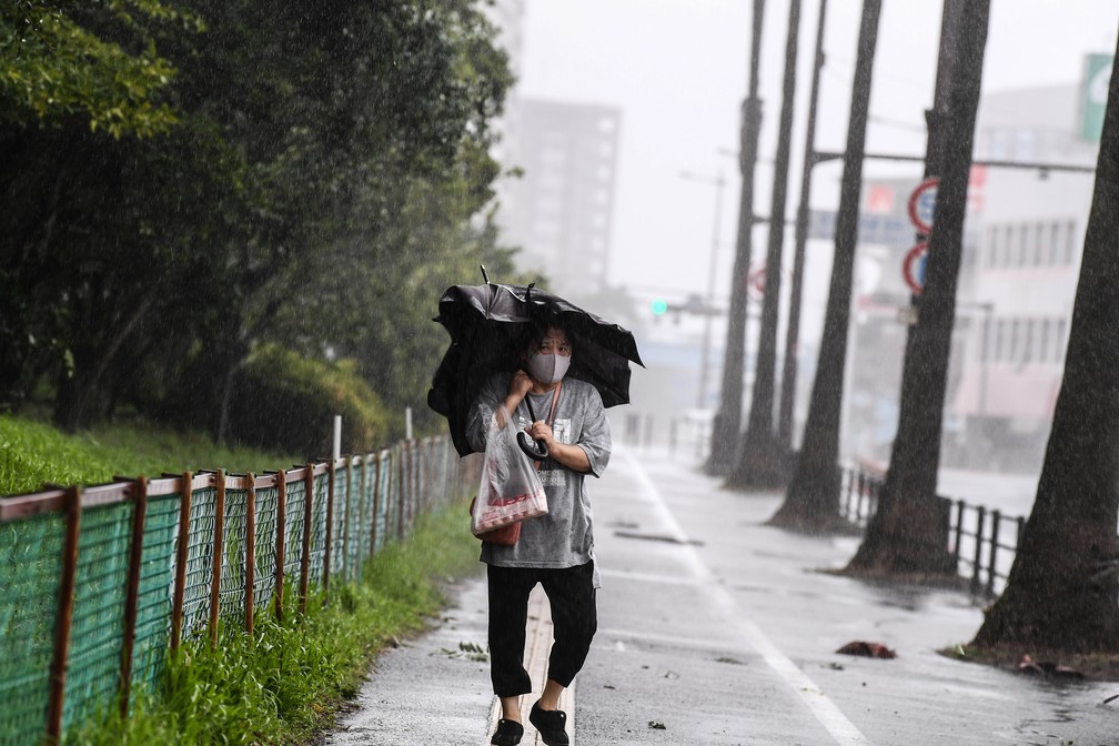 Moradora enfrenta os ventos fortes do tufão Haishen em Kagoshima, Japão — Foto: Charly Triballeau/AFP