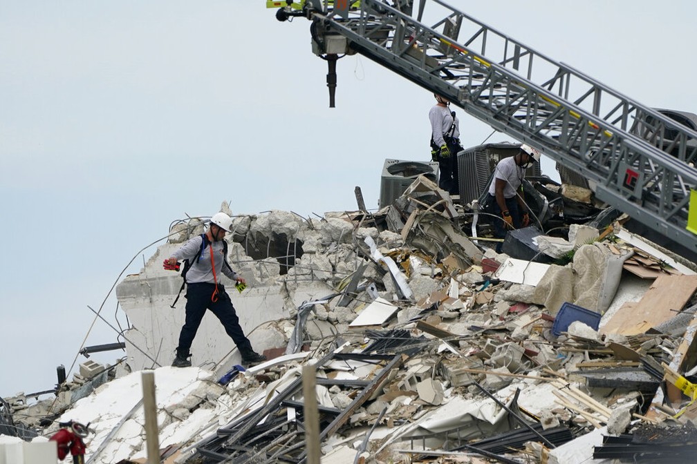 Socorristas vasculham escombros de prédio que caiu em Surfside, na região de Miami, nesta quinta-feira (24) — Foto: Lynne Sladky/AP Photo