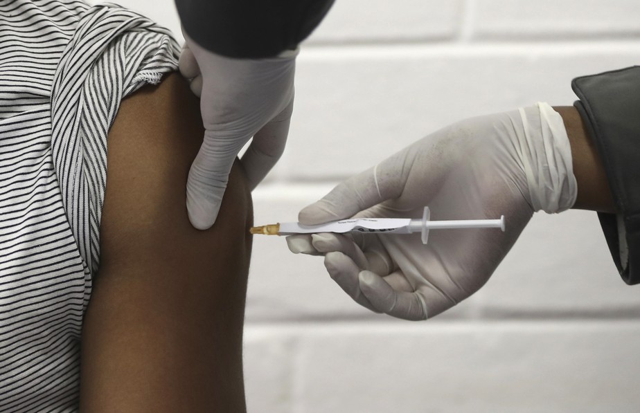 Na foto de arquivo de 24 de junho de 2020, um voluntário recebe uma injeção no hospital Chris Hani Baragwanath em Soweto, Joanesburgo, como parte da primeira participação da África em um ensaio de vacina contra covid-19 desenvolvido na Universidade de Oxford, na Grã-Bretanha, em conjunto com a empresa farmacêutica AstraZeneca