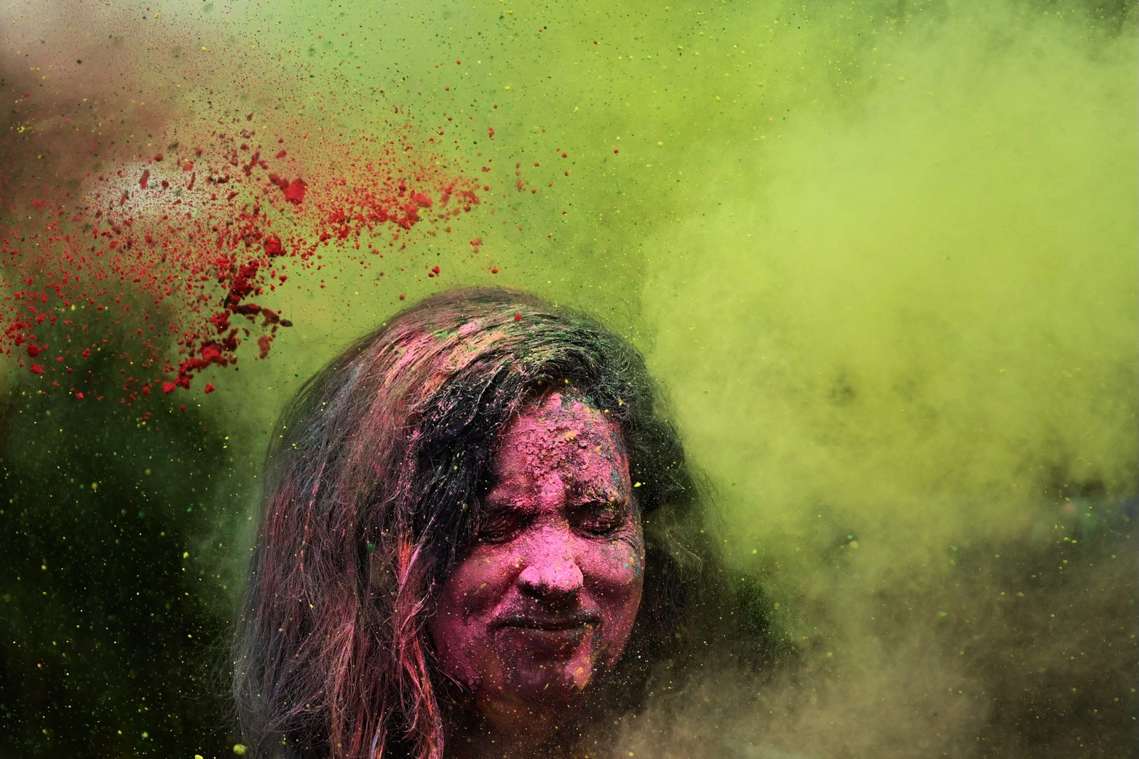 Folião toma banho de 'Gulal' (pó colorido) durante as celebrações do Holi, o festival hindu de cores da primavera, em Mumbai, Índia — Foto: INDRANIL MUKHERJEE/AFP