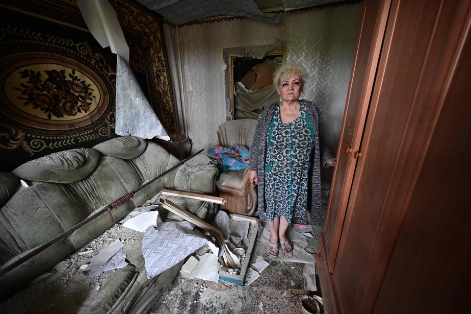 Uma mulher em seu apartamento parcialmente destruído como resultado de um míssil russo ter atingido um prédio residencial de quatro andares em Chasiv Yar, distrito de Bakhmut, Leste da Ucrânia