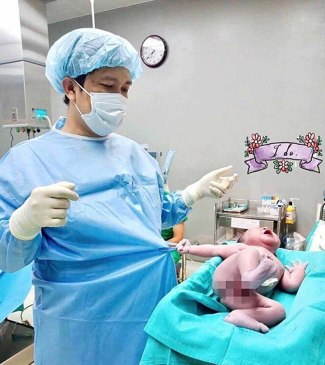 Recém-nascido segurando avental de médico (Foto: Reprodução Facebook)