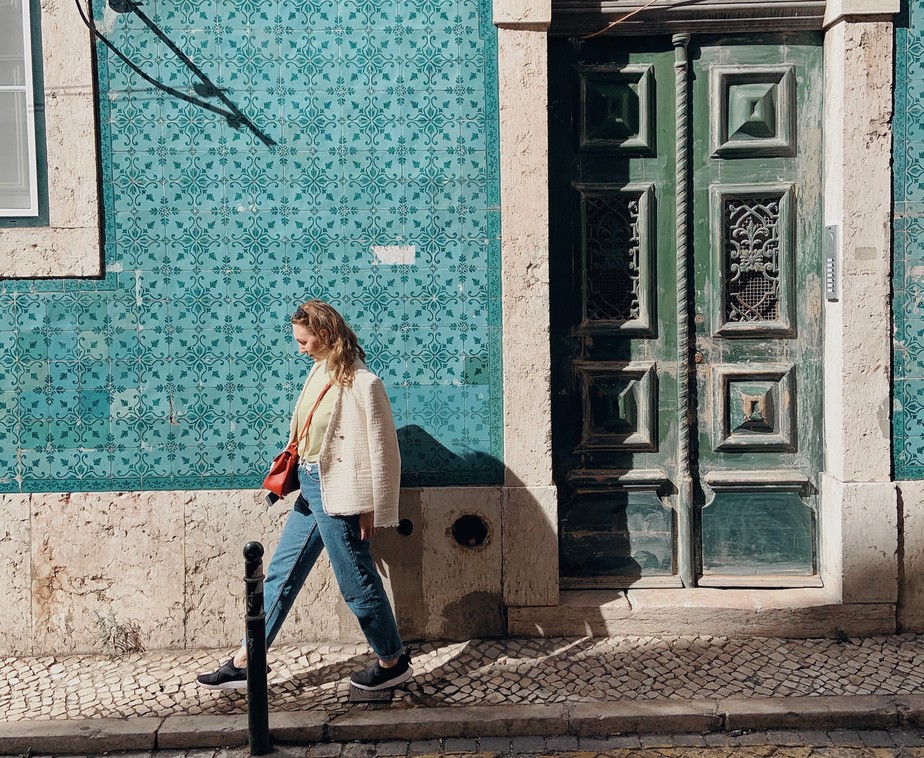Mulher caminha por rua de Lisboa