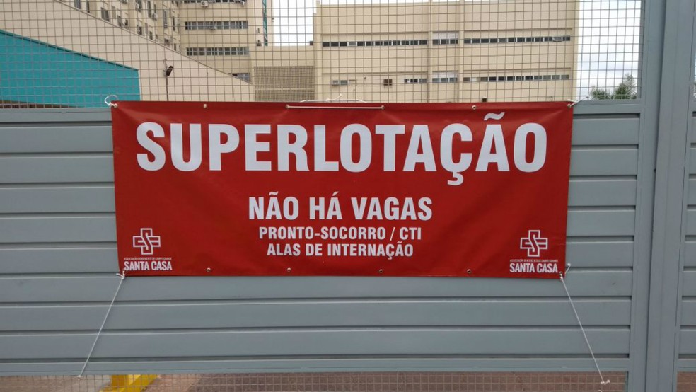 Faixa no portão de acesso as ambulâncias do SAMU e do Corpo de Bombeiros aponta que hospital não vai receber pacientes por conta da superlotação (Foto: Rodrigo Grando/TV Morena)