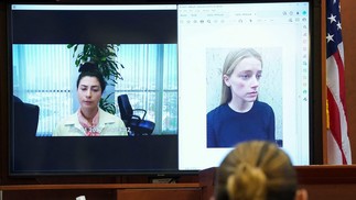Johnny Depp ouve depoimento de Raquel Pennington enquanto foto de Amber Heard é mostrada na tela durante julgamento por difamação contra sua ex-mulher no Tribunal do Condado de Fairfax, na Virgínia, EUA, em 18 de maio de 2022 — Foto: KEVIN LAMARQUE / AFP