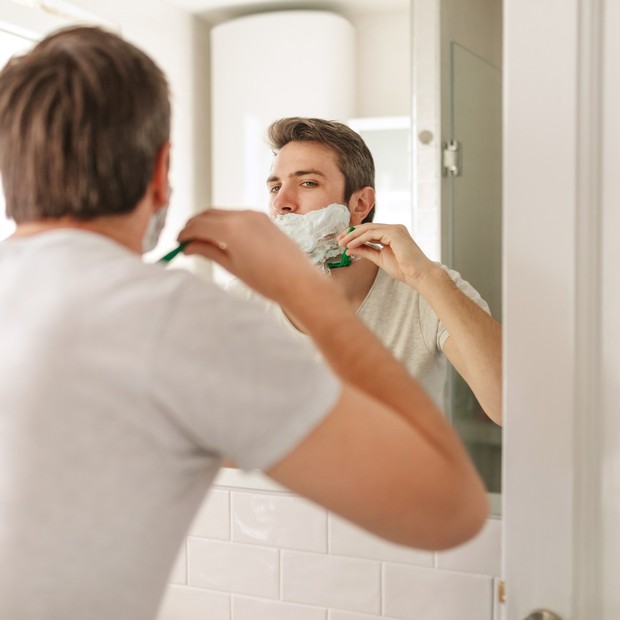 Young man's reflection in the mirror while shaving in the morning (Foto: Getty Images)