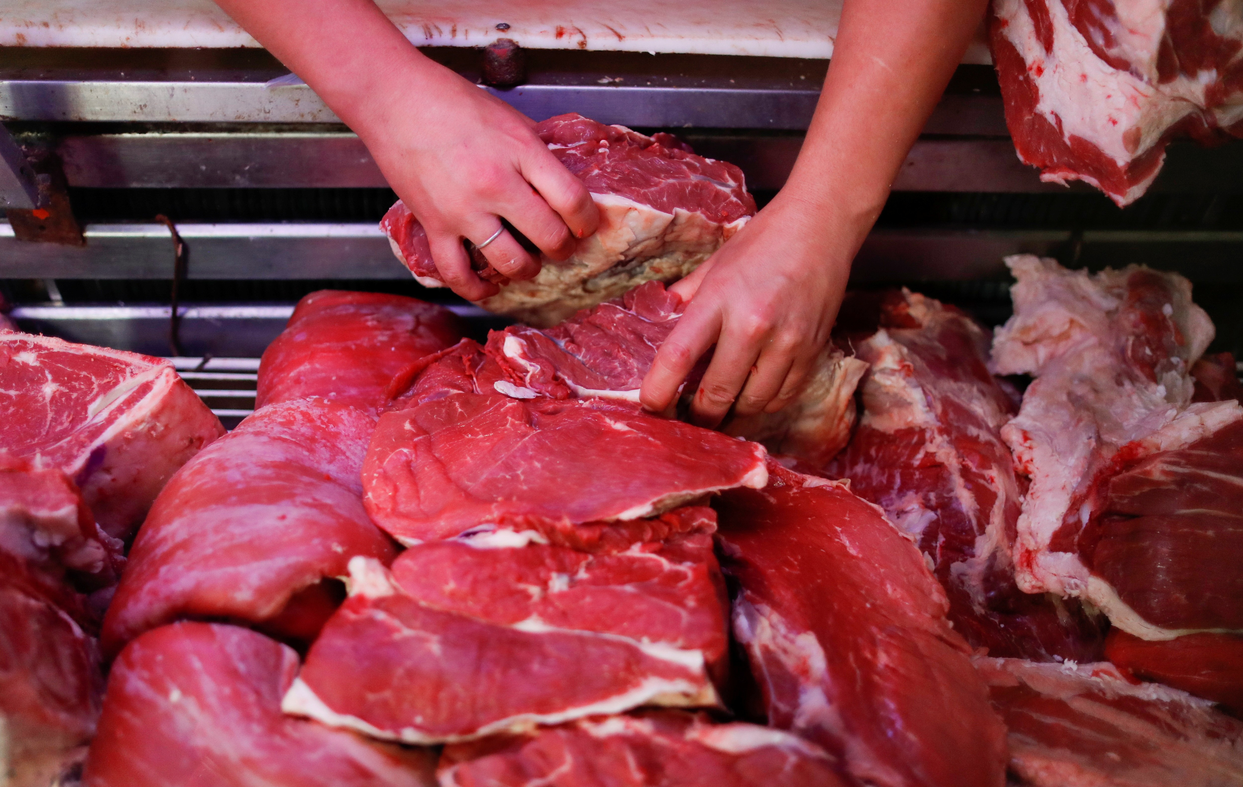 Pablo Alberto Monzón seleciona cortes de carne bovina em seu açougue em General Pacheco, Argentina 19/05/2021 (Foto: REUTERS/Agustin Marcarian)