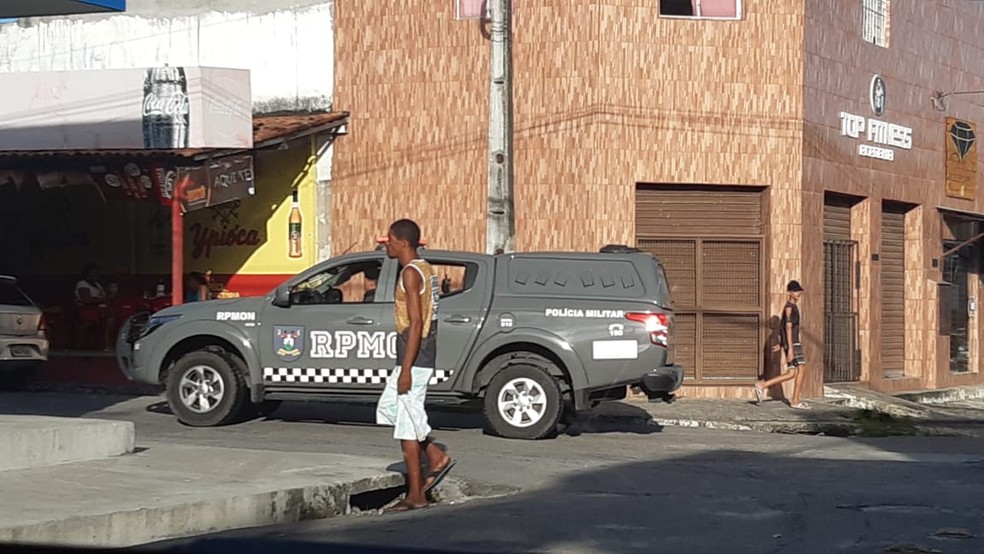 Moradores passam por viatura da Polícia Militar no bairro Mãe Luíza, em Natal — Foto: Sérgio Henrique Santos/Inter TV Cabugi