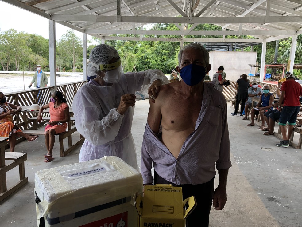 Líder comunitário, seu Raimundo não escondia a alegria em ser vacinado: "Já tenho 65 anos. Estou aqui prontinho".  — Foto: Matheus Castro/G1