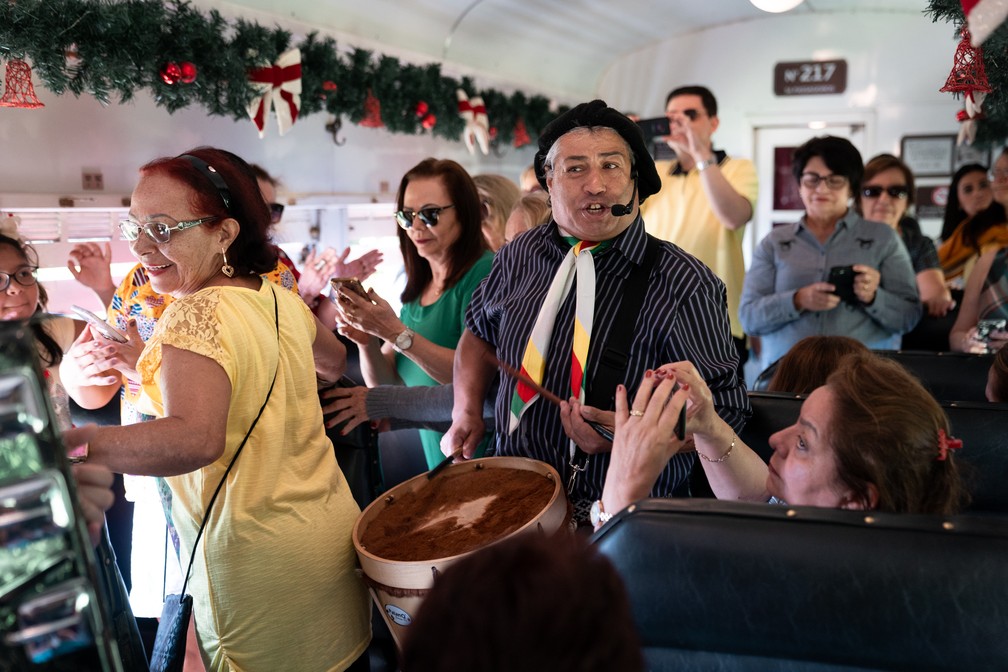 Turistas dançam ao som de música italiana em vagão da Maria Fumaça, em Bento Gonçalves e Garibaldi — Foto: Marcelo Brandt/G1
