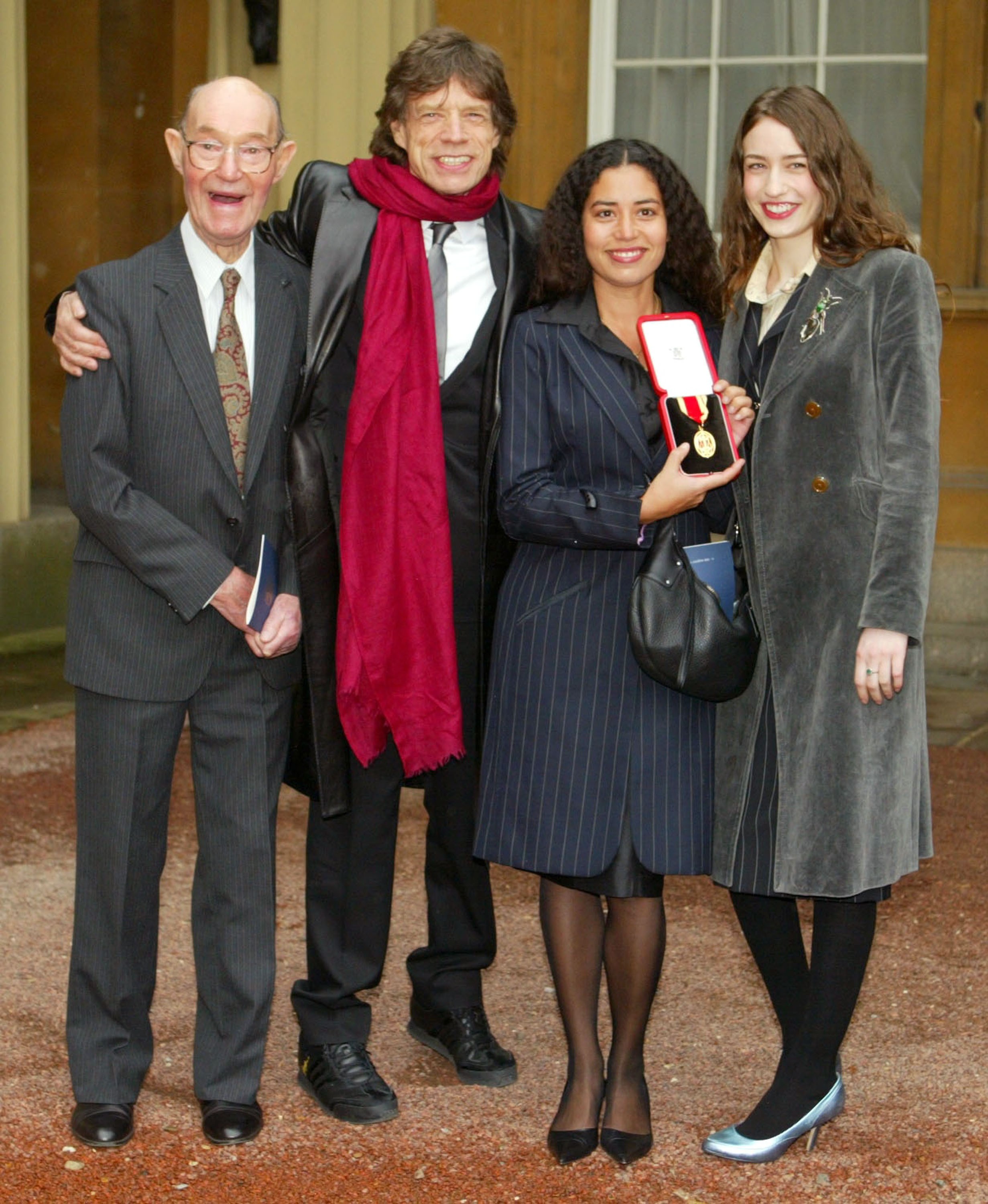 Mick Jagger e sua família ao receber o condecorado como Sir. pelos seus fetos à música (Foto: Getty Images)
