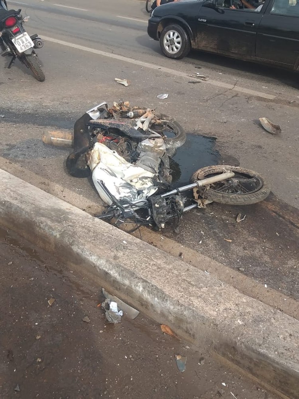 Motocicleta ficou destruída após ser esmagada por caminhão e carro — Foto: Divulgação