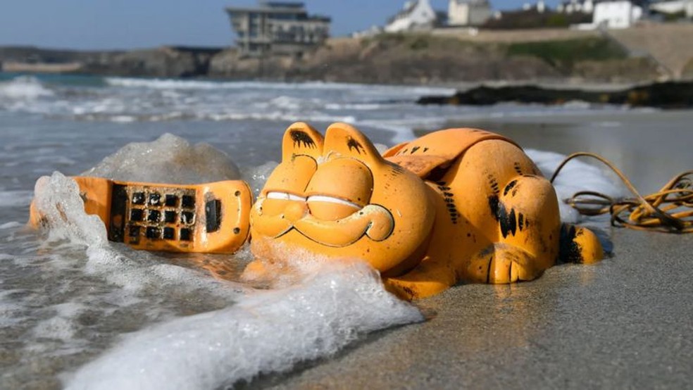 Telefones do personagem Garfield passaram anos aparecendo nas praias francesas até que a explicação fosse encontrada — Foto: Getty Images via BBC
