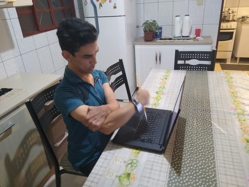 Jovem disse que a adaptaÃ§Ã£o com o pincel pra poder digitar foi o que mudou a vida dele  â Foto: Marcelo Zanello MillÃ©o/Arquivo pessoal 