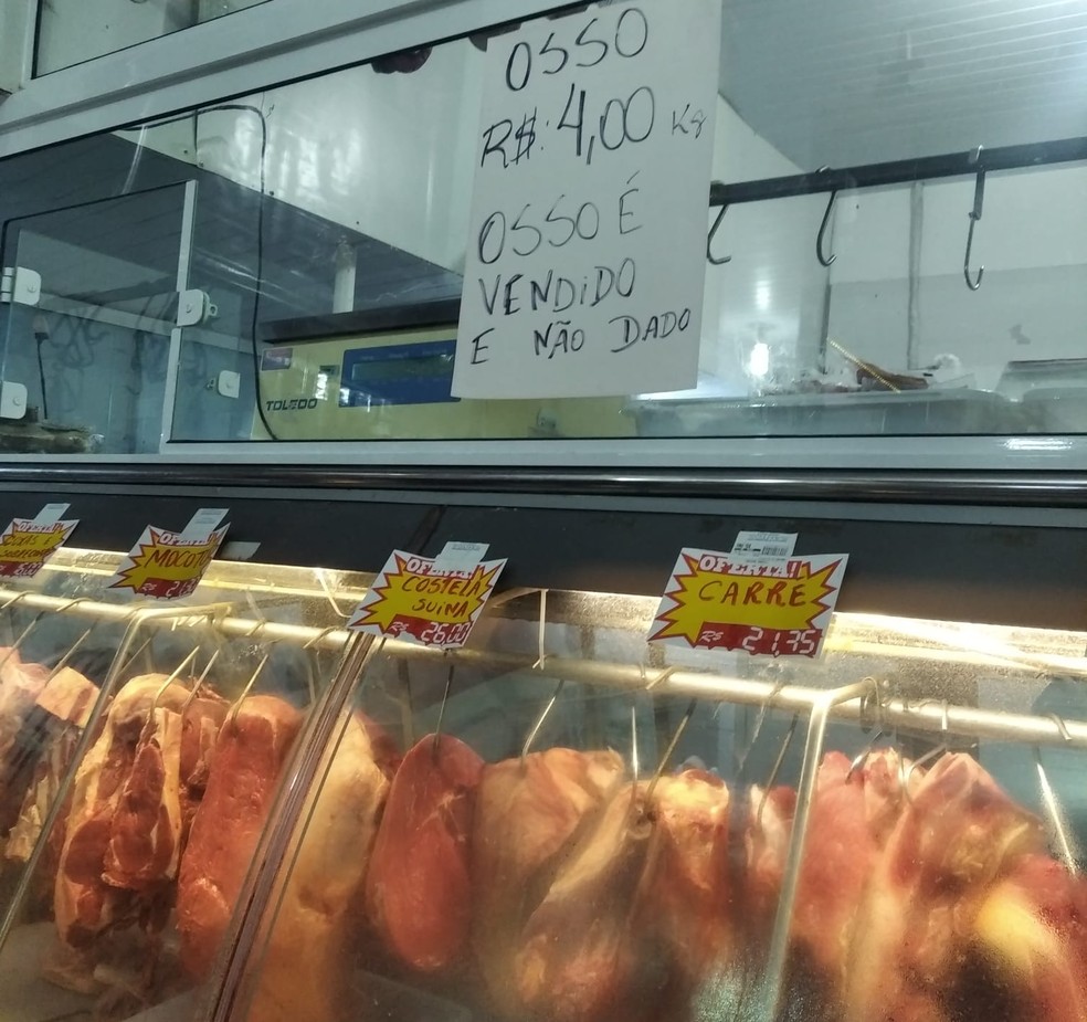 Comerciante colocou placa com preço do quilo de ossos de boi — Foto: Caroline Borges/G1 SC