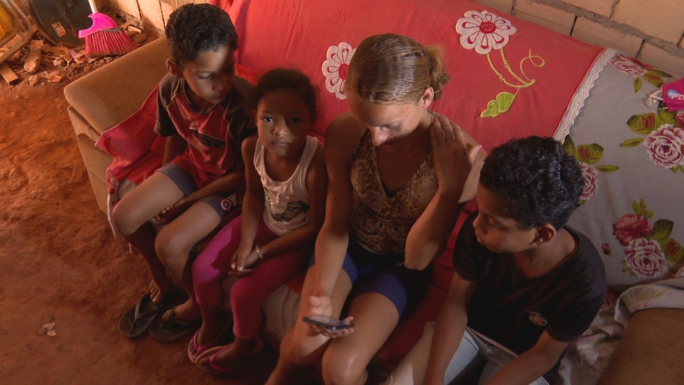 Mãe compartilha celular com três crianças em Santa Luzia, na Estrutural  — Foto: TV Globo/Reprodução 