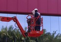 Diretor administrativo limpa fachada de prédio de 13 metros