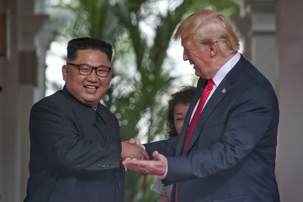 Kim Jong-un e Donald Trump sorriem ao se cumprimentar durante reunião em Singapura (Foto: Kevin Lim/The Straits Times via AP)