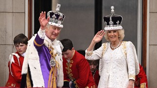 Charles III, vestindo a Coroa do Estado Imperial, e a rainha Camilla, com uma versão modificada da Coroa da Rainha Maria, acenam para os súdito da varanda do Palácio de Buckingham  — Foto: Oli SCARFF / AFP