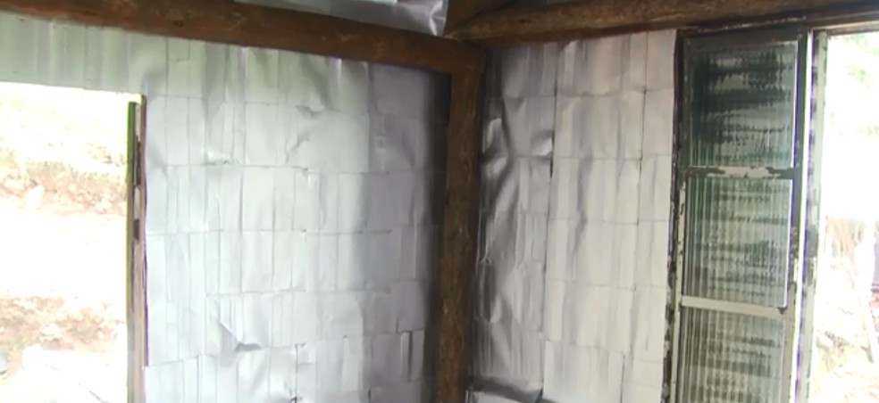 Caixas de leite são usadas para realizar isolamento térmico em casas de madeira de SC — Foto: Reprodução/NSC TV