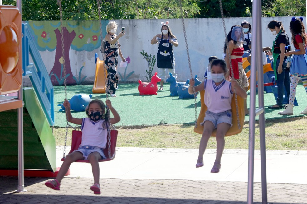 Meninas de máscara brincam em balanço na volta às aulas no Rio de Janeiro — Foto: Foto Ana Chaffin/Prefeitura de Macaé