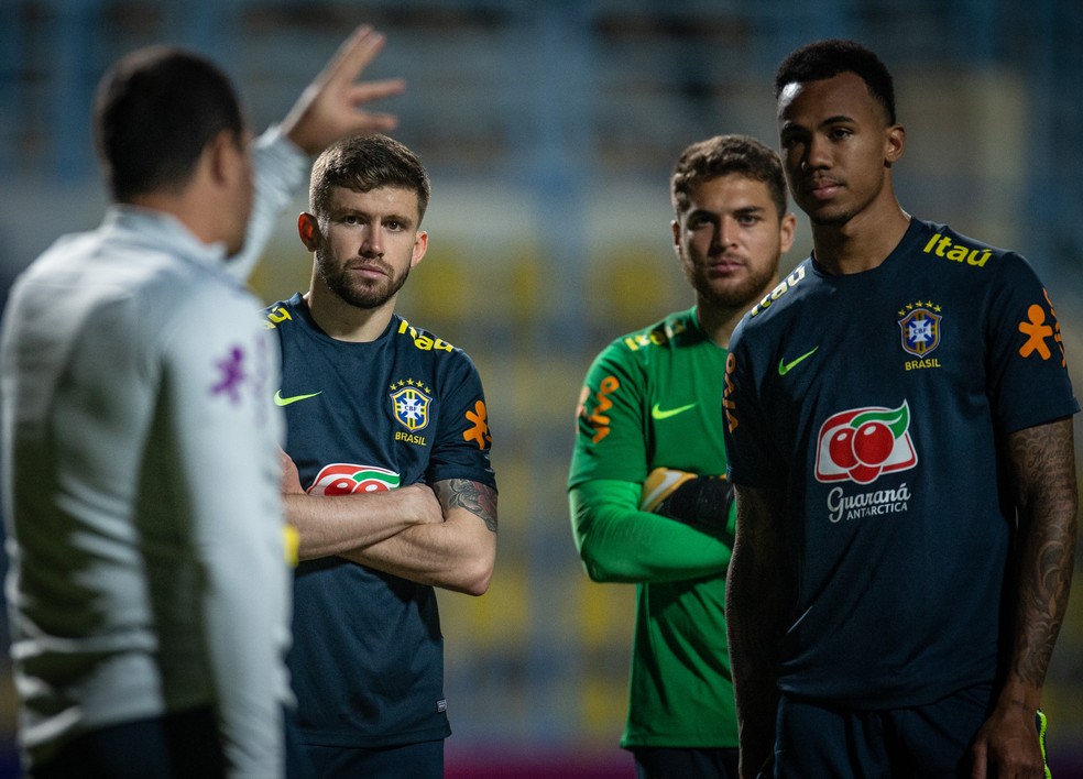 Gabriel Magalhães, ao lado de Caio Henrique, ouve instruções de André Jardine em treino da seleção olímpica — Foto: Ricardo Nogueira/CBF