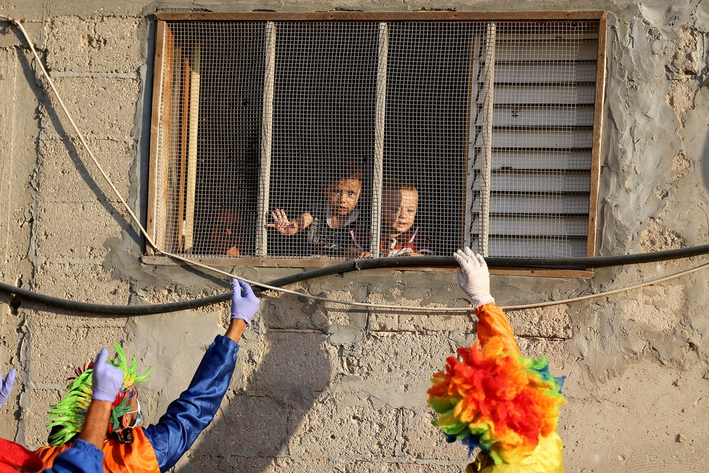 2 de setembro - Palhaços divertem crianças palestinas durante confinamento após pandemia de coronavírus (Covid-19) em Khan Younis, sul da Faixa de Gaza — Foto: Ibraheem Abu Mustafa/Reuters