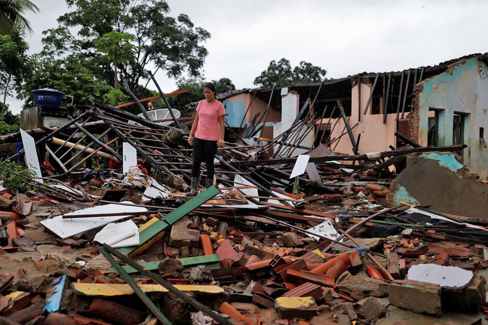 Juliana Reis, de 37 anos, é vista próxima aos escombros de sua casa, destruída pelas enchentes em Itambé, no sul da Bahia, nesta terça (28) — Foto:  Amanda Perobelli/Reuters