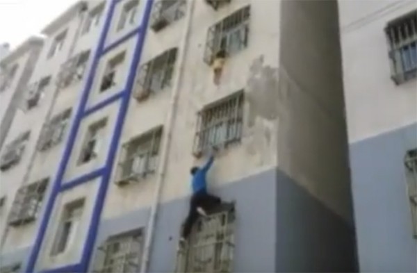 Chinês salva menino preso na grade de janela de apartamento (Foto: Reprodução / YouTube)