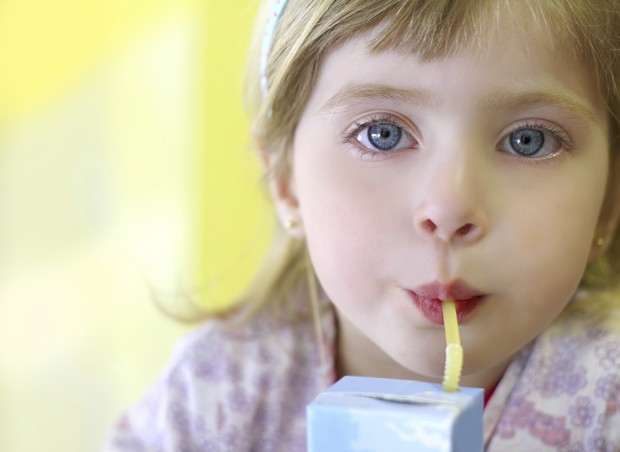 Menina bebendo suco de caixinha (Foto: Thinkstock)